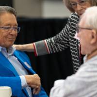 Jim Brooks sitting at table talking with Don Lubbers